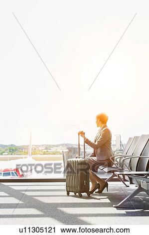 Stock Image - Portrait of businesswoman sititng while waiting for boarding in airport . Fotosearch