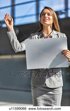 Portrait of businesswoman standing while holding blank white board in arrival area at airport View Large Photo Image Stock Photograph - Portrait of businesswoman standing while holding blank white board in arrival area at airport. Fotosearch