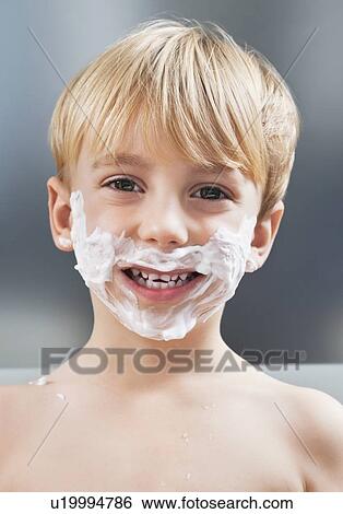 Stock Photograph - Portrait of Caucasian boy with shaving cream on his face. Fotosearch