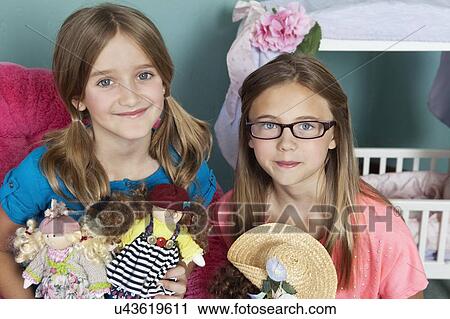 Stock Image - Portrait of Caucasian girls with dolls. Fotosearch