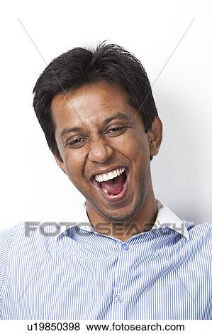 Stock Photo - Portrait of cheerful young Indian man against white background. Fotosearch