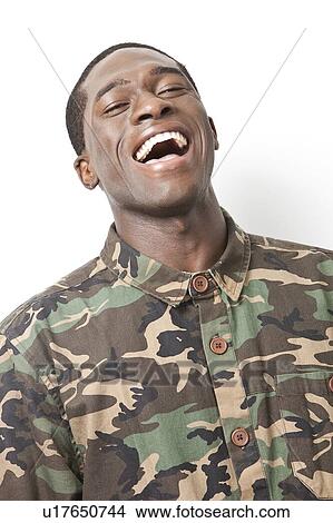 Picture - Portrait of cheerful young military soldier in camouflage clothing laughing against white background. Fotosearch