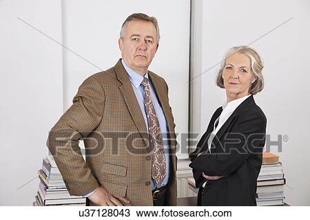Stock Image - Portrait of confident businessman and woman in office. Fotosearch