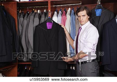 Portrait of confident man showing new suits in store View Large Photo Image Stock Photo - Portrait of confident man showing new suits in store. Fotosearch
