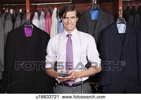 Portrait of confident man with calculator standing against display cabinet View Large Photo Image Stock Image - Portrait of confident man with calculator standing against display cabinet. Fotosearch