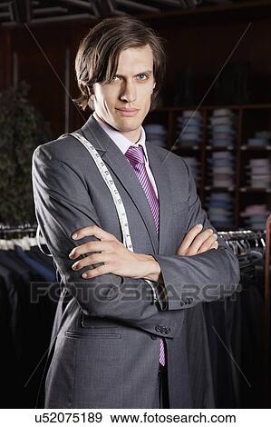 Stock Photo - Portrait of confident owner with arms crossed standing in store. Fotosearch