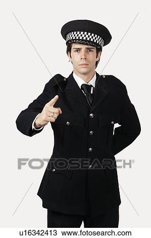 Portrait of confident police officer gesturing against gray background View Large Photo Image Stock Image - Portrait of confident police officer gesturing against gray background. Fotosearch