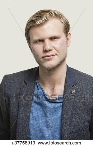 Portrait of confident young businessman against gray background View Large Photo Image Stock Photo - Portrait of confident young businessman against gray background. Fotosearch