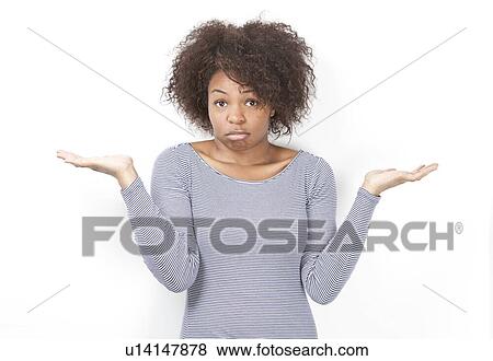 Stock Photo - Portrait of confused African American young woman shrugging against white background. Fotosearch