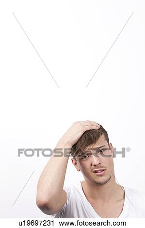 Portrait of confused young man against white background View Large Photo Image Stock Image - Portrait of confused young man against white background. Fotosearch