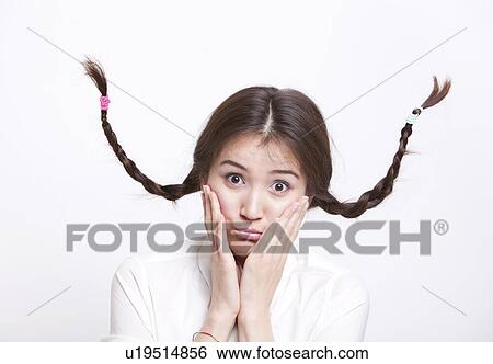 Portrait of confused young woman with braids curling upwards against white background View Large Photo Image Stock Photograph - Portrait of confused young woman with braids curling upwards against white background. Fotosearch