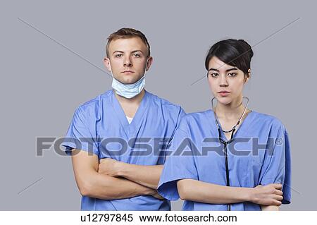 Portrait of female and male surgeons standing with arms crossed over gray background View Large Photo Image Stock Photography - Portrait of female and male surgeons standing with arms crossed over gray background. Fotosearch