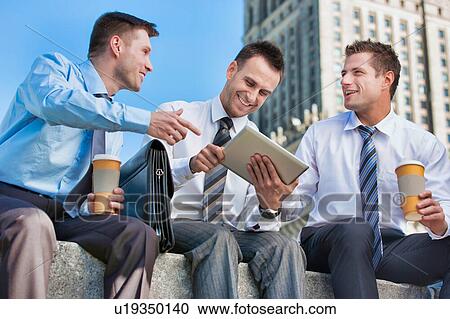 Portrait of handsome businessman showing business plan to the other businessman over digital tablet while sitting View Large Photo Image Stock Image - Portrait of handsome businessman showing business plan to the other businessman over digital tablet while sitting. Fotosearch