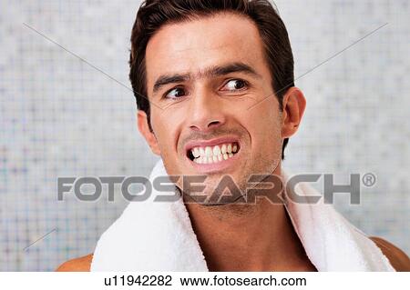 Portrait of handsome man looking on the mirror while checking on his teeth View Large Photo Image Stock Image - Portrait of handsome man looking on the mirror while checking on his teeth . Fotosearch