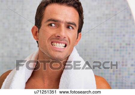Portrait of handsome man looking on the mirror while checking on his teeth View Large Photo Image Stock Image - Portrait of handsome man looking on the mirror while checking on his teeth . Fotosearch