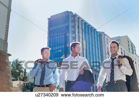 Stock Photo - Portrait of handsome mature businessmen walking while talking after work. Fotosearch