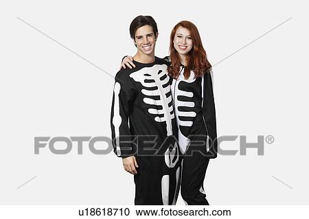Portrait of happy couple in skeleton costume against gray background View Large Photo Image Stock Image - Portrait of happy couple in skeleton costume against gray background. Fotosearch