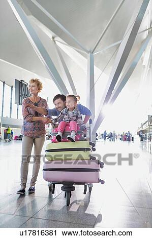 Portrait of happy family going on a holiday in airport View Large Photo Image Stock Image - Portrait of happy family going on a holiday in airport. Fotosearch