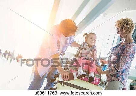 Stock Image - Portrait of happy family going on a holiday in airport. Fotosearch