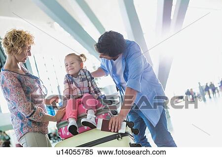Stock Photography - Portrait of happy family going on a holiday in airport. Fotosearch
