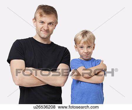 Stock Photo - Portrait of happy father and son in casuals with arms crossed over white background. Fotosearch