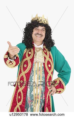 Stock Photo - Portrait of happy king with hand gesture over gray background. Fotosearch