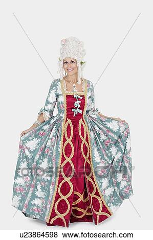 Stock Photo - Portrait of happy senior queen standing over gray background. Fotosearch