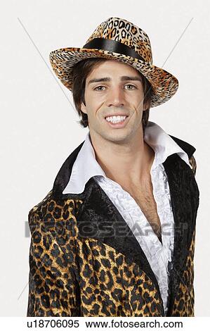 Stock Photography - Portrait of happy young man in fur clothing against gray background. Fotosearch