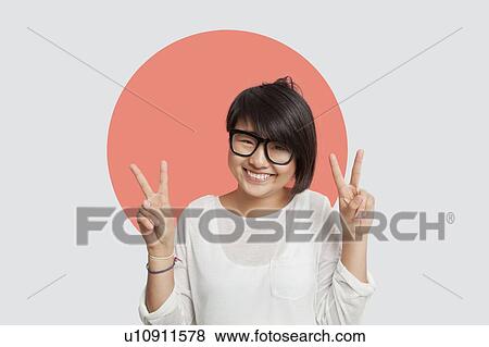 Portrait of happy young woman gesturing peace sign against Japanese flag View Large Photo Image Stock Photo - Portrait of happy young woman gesturing peace sign against Japanese flag. Fotosearch