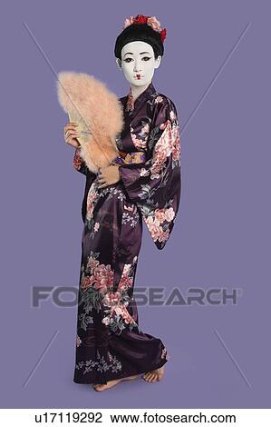 Portrait of Japanese woman in kimono holding folding fan against purple background View Large Photo Image Stock Image - Portrait of Japanese woman in kimono holding folding fan against purple background. Fotosearch