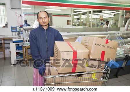 Stock Photo - Portrait of male worker with shopping cart. Fotosearch