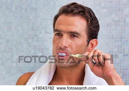 Portrait of man brushing his teeth while looking in to the mirror View Large Photo Image Stock Image - Portrait of man brushing his teeth while looking in to the mirror. Fotosearch