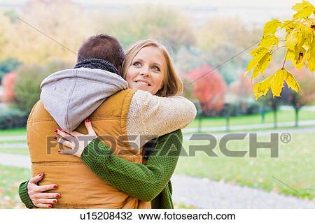 Portrait of man embracing his beautiful wife in park View Large Photo Image Stock Image - Portrait of man embracing his beautiful wife in park. Fotosearch