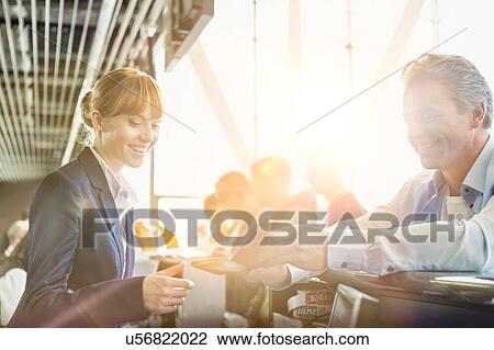 Stock Image - Portrait of man giving his passport for check in with passenger service agent at airport . Fotosearch