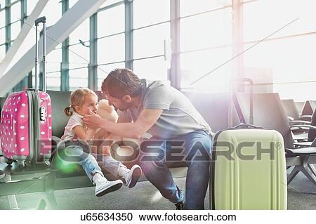 Portrait of man playing with her daughter while sitting and waiting for boarding in airport View Large Photo Image Stock Image - Portrait of man playing with her daughter while sitting and waiting for boarding in airport. Fotosearch