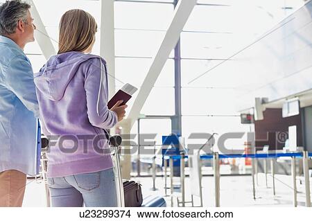 Portrait of man pushing baggage cart for check in with her daughter at airport View Large Photo Image Picture - Portrait of man pushing baggage cart for check in with her daughter at airport. Fotosearch