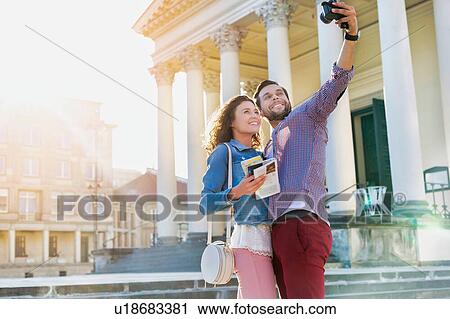 Stock Image - Portrait of Man taking selfie with his girlfriend. Fotosearch