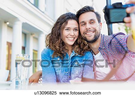 Stock Photography - Portrait of man taking selfie with his beautiful girlfriend. Fotosearch