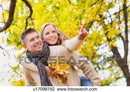 Portrait of mature attractive man giving his wife a piggy ride back in park View Large Photo Image Stock Image - Portrait of mature attractive man giving his wife a piggy ride back in park. Fotosearch