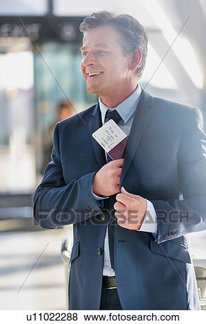 Portrait of mature attractive businessman taking out his passport from his suit in airport View Large Photo Image Stock Photo - Portrait of mature attractive businessman taking out his passport from his suit in airport. Fotosearch