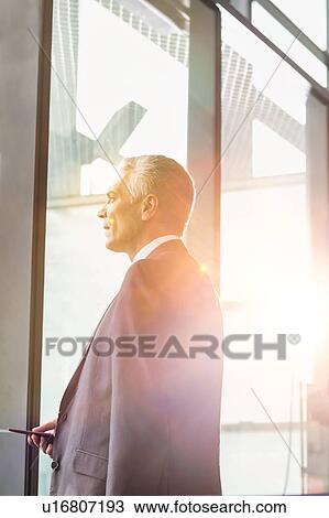 Stock Image - Portrait of Mature businessman boarding on the plane in airport. Fotosearch