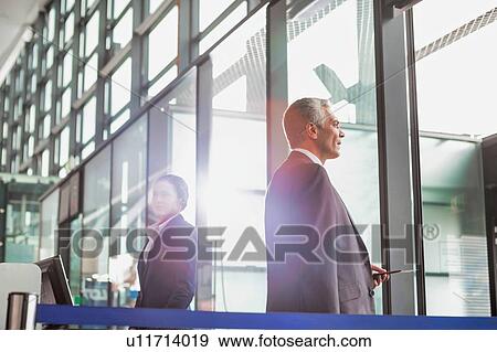 Stock Photo - Portrait of Mature businessman boarding on the plane in airport. Fotosearch
