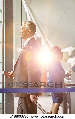 Stock Photography - Portrait of Mature businessman boarding on the plane in airport. Fotosearch