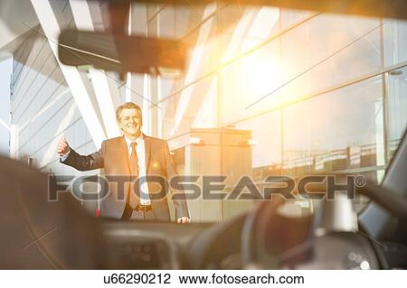 Portrait of mature businessman calling taxi in the airport with yellow lens flare View Large Photo Image Stock Image - Portrait of mature businessman calling taxi in the airport with yellow lens flare. Fotosearch