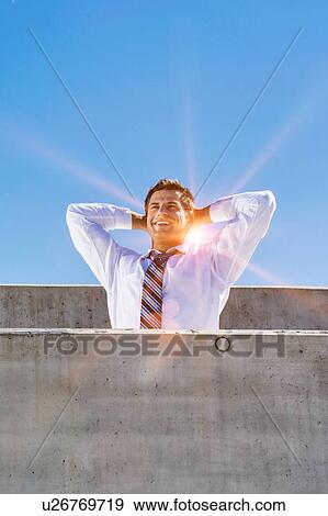 Stock Photo - Portrait of mature businessman relaxing on rooftop . Fotosearch