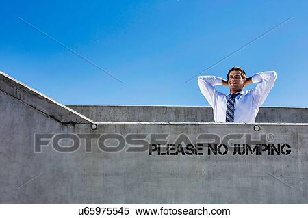 Stock Photography - Portrait of mature businessman relaxing on rooftop . Fotosearch