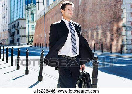 Stock Photograph - Portrait of mature confident man walking on pavement. Fotosearch