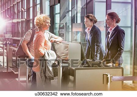 Portrait of mature couple asking airport staff with lens flare View Large Photo Image Stock Image - Portrait of mature couple asking airport staff with lens flare. Fotosearch