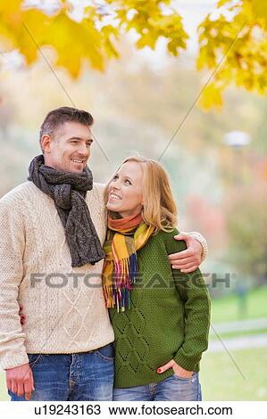 Stock Image - Portrait of Mature couple enjoying autumn while walking in park . Fotosearch
