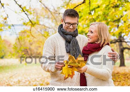 Portrait of mature couple holding maple leaves in park View Large Photo Image Stock Image - Portrait of mature couple holding maple leaves in park. Fotosearch